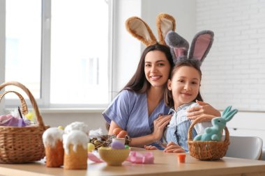Küçük kız ve annesi tavşan kulaklı Paskalyayı mutfakta kutluyorlar.