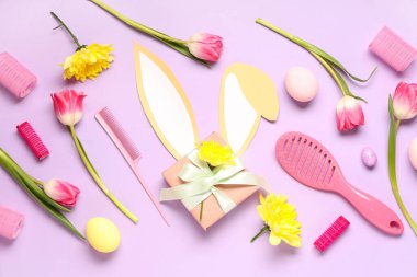 Kuaför malzemeleri, bahar çiçekleri ve renk arkaplanlı Paskalya yumurtaları.