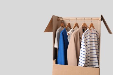 Gri arka planda giysileri olan kostüm kutusu.