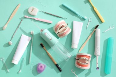 Ağız temizliği için ağız temizleyicisi ve turkuaz arka planda dişçi aletleri ayarlandı