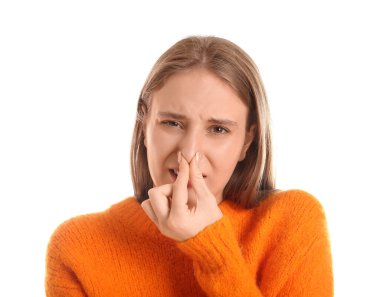 Genç bir kadın beyaz arka planda korkunç bir koku hissediyor.