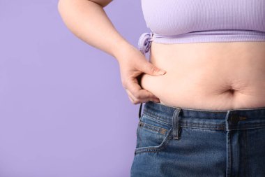 Leylak arka planda şişman bir kadın, yakın plan. Diyet kavramı