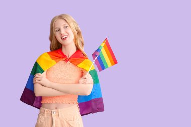 Mor arka planda LGBT bayrağı olan güzel, genç ve mutlu bir kadın.