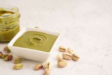 Fıstıklı ezme kasede ve kavanozda beyaz arka planda