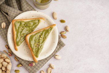 Hafif arka planda fıstık ezmeli tabak ve ekmek parçaları.