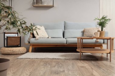 Gri kanepe, masa ve dergi standı olan aydınlık oturma odasının içinde.