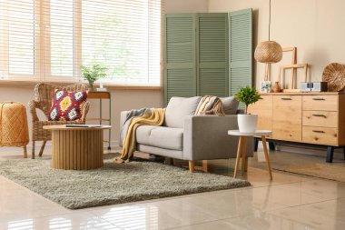 Işıl ışıl oturma odasının içinde rahat bir kanepe ve sehpa var.