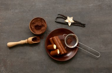 Kaymak tabaklı tabaklar ve siyah grunge arka planda pudra kahve.