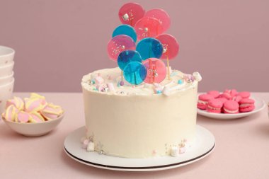 Doğum günü partisi için şekerli pasta pembe duvarın karşısında.