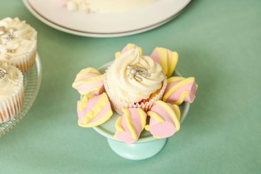 Turkuaz masada doğum günü partisi için lezzetli beyaz kek ve şekerlemelerle tatlı standı.