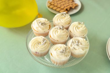 Turkuaz masada doğum günü partisi için lezzetli beyaz keklerle tatlı standı, yakın plan.