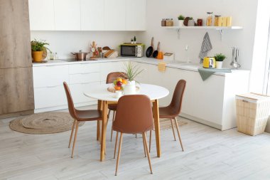 Mutfağın içinde yemek masası ve tezgahları var.