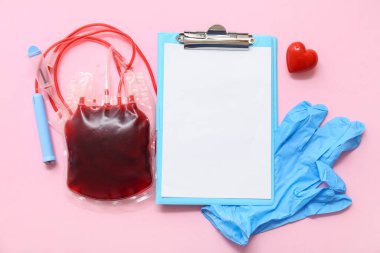 Boş dosya, kan torbası, lastik eldiven ve pembe arka planda kalp. Dünya Kan Bağışı Günü