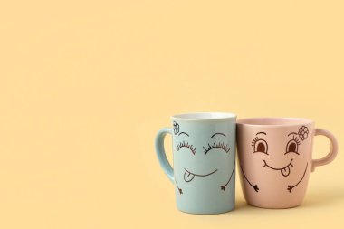 Renkli arka planda komik yüzlü fincanlar. Dostluk Günü kutlaması