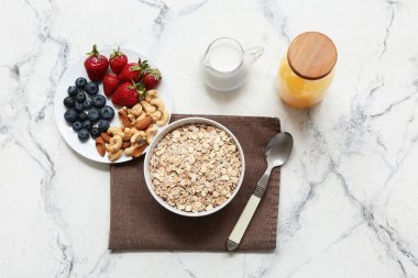 Peçete, fındık, böğürtlen ve mermer arka planda çiğ yulaf ezmesi