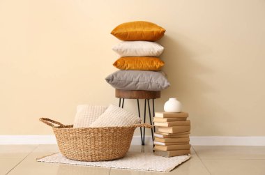 Sandalyede bir yığın yumuşak yastık ve şık bir odada kitaplar.