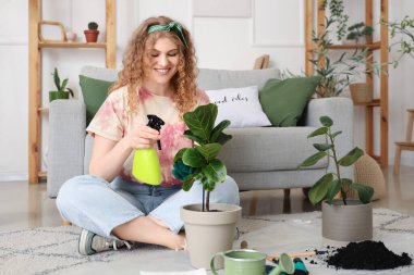 Evde yeşil bitkiyle ilgilenen genç bir kadın.