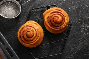 Siyah arka planda tatlı tarçınlı rulolarla dur