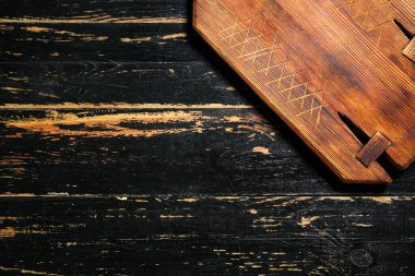 Siyah masanın üzerindeki tahta kesme tahtası, yakın plan.