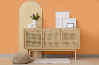 Vazodaki yabani çiçekler ve odadaki çekmecelerin üzerindeki çerçeveler.