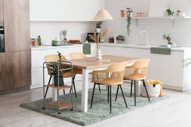 Modern yemek odasının içinde masa ve sandalyeler var.