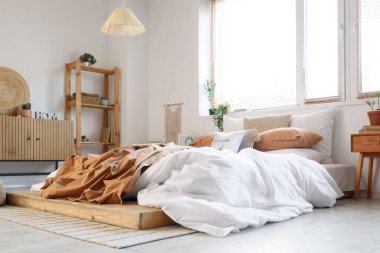 Yatak odasının içi, büyük yatak odası, çekmeceler, raf ünitesi ve komodinli.