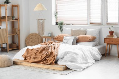 Yatak odasının içi büyük yatak odası, raf ünitesi ve komodinlerle dolu.