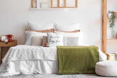 Muffin, komodin, raflar ve yatak odasının içi puf dolu büyük, rahat bir yatak.