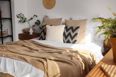 Yatak odasının iç kısmında yumuşak yastıklar olan büyük bir yatak.