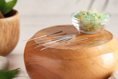 Akupunktur iğneleri ve ahşap tezgahta deniz tuzu.