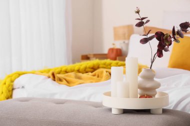 Okaliptüs dallı vazo, mum ve balkabağı yatak odasında, yakın plan.