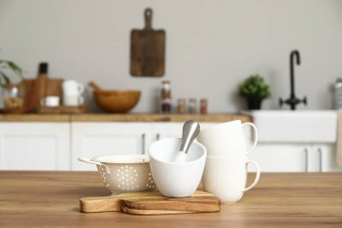 Bardaklar, süzgeçler, yemek, harç ve tokmak mutfaktaki ahşap tezgahta.