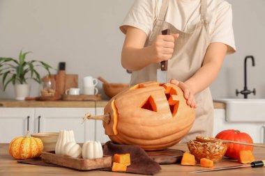 Mutfakta tezgahta balkabağı oyan kadın.