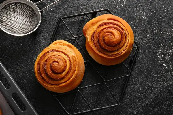 Siyah arka planda tatlı tarçınlı rulolarla dur