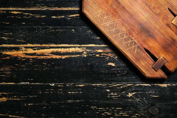 Siyah masanın üzerindeki tahta kesme tahtası, yakın plan.