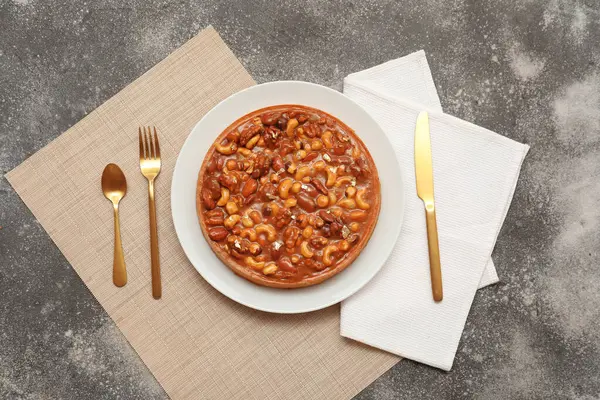 Farklı fındıklı tatlı tart ve gri arkaplanda karamel.