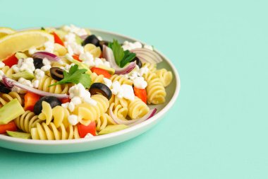 Turkuaz arka planda geleneksel makarna salatası ile tabak