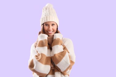 Leylak arka planında kalın giyinmiş genç bir kadın.