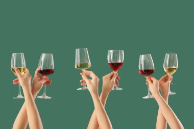 Yeşil arka planda farklı şarapların kadehlerini tutan kadın eller.