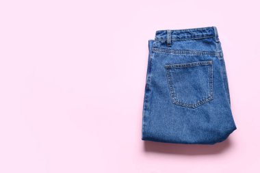 Pembe arka planda şık pantolonlar.