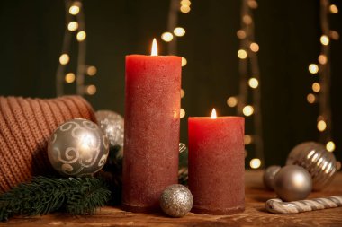 Mumları yakmak ve Noel ışıklarını karanlık arka planda tutmak