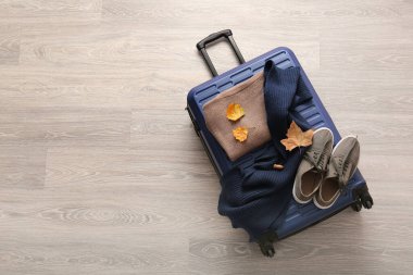 Bavul, giysi, ayakkabı ve sonbahar yapraklı güzel kompozisyon açık ahşap arka planda