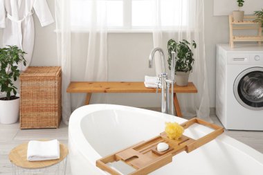 Banyonun içinde küvet ve ahşap bank var.