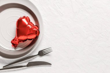 Beyaz arka planda kalp şeklinde hava balonu olan güzel bir masa. Sevgililer Günü kutlaması