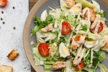 Beyaz arka planda lezzetli tavuklu Sezar salatası, yakın plan.