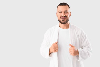 Beyaz arka planda gülümseyen genç adam.