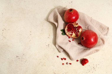 Beyaz zemin üzerinde tohum ve yapraklarla taze olgun nar.