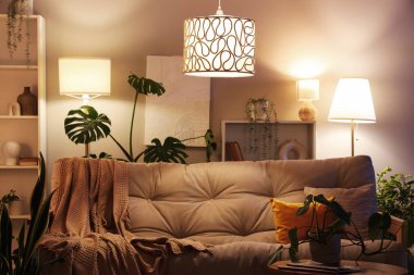 Oturma odasının içinde rahat bir kanepe ve geceleri çiçekli kahve masası.