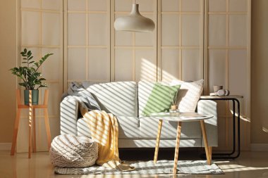 Katlanmış perdeli, kanepeli ve masalı bir oturma odası.