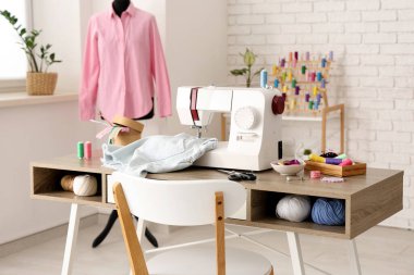 Terzinin dikiş makinesi, farklı malzemeler ve atölye mankeni.